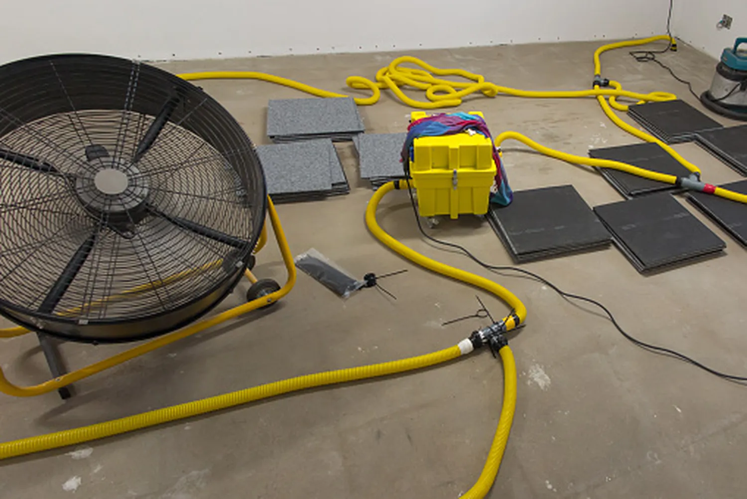 Kanzler Facility GmbH - Hausmeisterservice, Reinigung, sanierung & Wasserschadensanierung - Trocknen eines Betonbodens unter einer Stoffabdeckung.